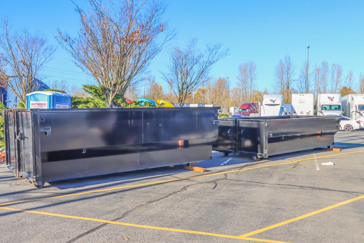 Professional dumpster rental service with roll-off container on residential driveway in Langley Park